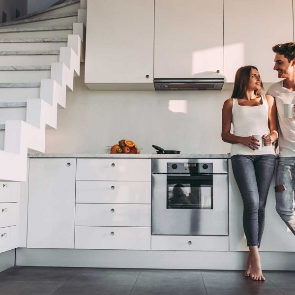 happy-couple-standing-in-front-modern-splashback (745090438)