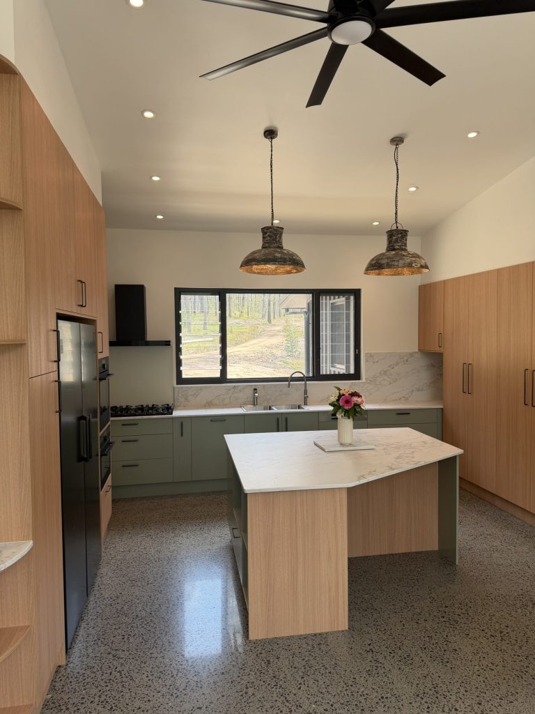 Nooroo kitchen near Stroud with Bayleaf green cabinetry, Blackbutt timber tall pantry and Quantum Quartz Antico island